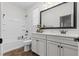 Bright bathroom with a tub-shower, white vanity, marble countertop, and elegant framed mirror at 2207 Valdina St, Henderson, NV 89044