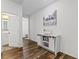 Hallway with decorative cabinet and wood flooring, leading to bathroom and bedrooms at 2207 Valdina St, Henderson, NV 89044