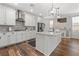 Elegant kitchen featuring white cabinets, a gray backsplash, stainless steel appliances, and an island at 2207 Valdina St, Henderson, NV 89044