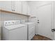 Efficient laundry room with overhead cabinets, washer, and dryer for household convenience at 2207 Valdina St, Henderson, NV 89044