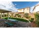 Lush backyard featuring manicured landscaping and a covered patio with picnic table at 2418 Brockton Way, Henderson, NV 89074