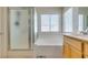 Well-lit bathroom featuring a soaking tub and glass enclosed shower at 2418 Brockton Way, Henderson, NV 89074
