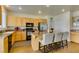 Functional kitchen with stainless appliances, granite counters, breakfast bar with seating, and hardwood floors at 2418 Brockton Way, Henderson, NV 89074