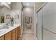 Bright and functional bathroom with a glass shower, light wood cabinets, and double sinks at 2537 Nashira St, Henderson, NV 89044