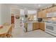 Bright kitchen featuring wood cabinets, white appliances, and light wood-look flooring for a modern, clean aesthetic at 2537 Nashira St, Henderson, NV 89044