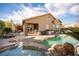 Backyard featuring a pool, spa, outdoor kitchen, covered patio, and lounge area for relaxation and entertaining at 340 Autumn Palace Ct, Las Vegas, NV 89144