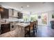 Well-lit kitchen with stainless steel appliances, a large island with bar stools, and views of the landscaped yard at 340 Autumn Palace Ct, Las Vegas, NV 89144