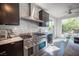 Modern kitchen featuring a stainless steel range, marble backsplash, and an adjacent breakfast nook with outdoor views at 340 Autumn Palace Ct, Las Vegas, NV 89144