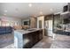 Open kitchen layout featuring stainless steel appliances, an island with seating, and a view into the living area at 340 Autumn Palace Ct, Las Vegas, NV 89144