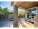 Comfortable covered patio with stone columns, offering a relaxing outdoor space with views of the landscaped yard at 340 Autumn Palace Ct, Las Vegas, NV 89144