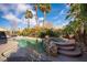 Sparkling pool and spa surrounded by lush greenery and palm trees in a serene backyard setting at 340 Autumn Palace Ct, Las Vegas, NV 89144