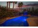 Inviting backyard pool and spa surrounded by lush greenery and mature palm trees at twilight at 340 Autumn Palace Ct, Las Vegas, NV 89144