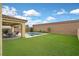 Spacious backyard features a pool, turf, patio with seating, and string lights overhead at 404 Lost Horizon Ave, Henderson, NV 89002