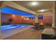 Covered patio with outdoor seating area overlooks pool and backyard with string lights at 404 Lost Horizon Ave, Henderson, NV 89002
