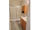 This bathroom has a wood-style floor, a shower with sliding glass doors and wooden cabinets at 4718 Victoria Garden Ave, North Las Vegas, NV 89031