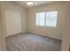 A cozy bedroom with plush carpeting, a large window, and a spacious closet at 4718 Victoria Garden Ave, North Las Vegas, NV 89031