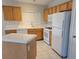 The kitchen has white appliances, an island, tile countertops, and light wood cabinets at 4718 Victoria Garden Ave, North Las Vegas, NV 89031