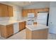 Kitchen with white appliances, an island, and light wood cabinetry at 4718 Victoria Garden Ave, North Las Vegas, NV 89031