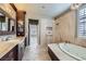 Luxurious bathroom featuring a soaking tub, walk-in shower, and marble accents at 4750 Fiore Bella Blvd, Las Vegas, NV 89135