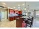 Open kitchen featuring tile floors, dark cherry cabinets, a mosaic backsplash, and pendant lighting at 4750 Fiore Bella Blvd, Las Vegas, NV 89135