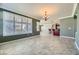 Spacious living room featuring plantation shutters, chandelier, and tile flooring at 4750 Fiore Bella Blvd, Las Vegas, NV 89135