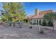 Landscaped backyard with desert plants, patio, and mature trees offering shade and privacy at 5008 Shoal Creek Cir, Las Vegas, NV 89113