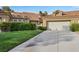 Inviting home exterior with well-maintained landscaping, a green lawn, and a spacious garage at 5008 Shoal Creek Cir, Las Vegas, NV 89113