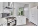 Modern kitchen with breakfast bar and stainless range, view into Gathering room, and luxury stainless vent hood at 5008 Shoal Creek Cir, Las Vegas, NV 89113