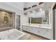 Bright bathroom featuring walk in shower, bathtub, and dual sinks with a large mirror at 5008 Shoal Creek Cir, Las Vegas, NV 89113