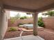 Covered patio view of the backyard with an above ground hot tub and gravel ground cover at 5052 Whistling Acres Ave, Las Vegas, NV 89131