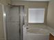 Bathroom featuring a standing shower next to a soaking tub and window at 5052 Whistling Acres Ave, Las Vegas, NV 89131