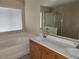 Bathroom featuring a soaking tub next to the double sink vanity at 5052 Whistling Acres Ave, Las Vegas, NV 89131