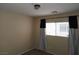 Bedroom with window covered by blinds and decorative curtains, neutral walls and trim at 5052 Whistling Acres Ave, Las Vegas, NV 89131