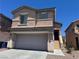Two-story home with a large garage, neutral color palette, and minimal landscaping at 5052 Whistling Acres Ave, Las Vegas, NV 89131