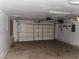 A spacious garage with a roll-up door and plenty of room for vehicles and storage at 5052 Whistling Acres Ave, Las Vegas, NV 89131