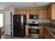 Kitchen featuring granite countertops, stainless steel appliances, and wood cabinetry at 5052 Whistling Acres Ave, Las Vegas, NV 89131