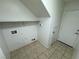 The laundry room has tile floors, a utility sink, and a storage shelf at 5052 Whistling Acres Ave, Las Vegas, NV 89131