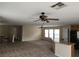 Spacious living room with neutral paint, carpet flooring, ceiling fans, and window views at 5052 Whistling Acres Ave, Las Vegas, NV 89131