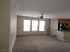 Open-concept living room with large windows and a view of the kitchen at 5052 Whistling Acres Ave, Las Vegas, NV 89131