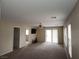 Bright living room featuring neutral walls and carpet, ceiling fan, and sliding glass doors at 5052 Whistling Acres Ave, Las Vegas, NV 89131