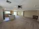 Expansive living area with generous natural light, carpet, and a kitchen view at 5052 Whistling Acres Ave, Las Vegas, NV 89131