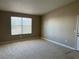 Spacious carpeted living room featuring neutral paint, trim and ample natural light from a large window at 5055 W Hacienda Ave # 2102, Las Vegas, NV 89118