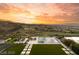 Backyard oasis featuring a modern pool, manicured lawn, and a scenic mountain view at sunset at 515 Serenity Point Dr, Henderson, NV 89012