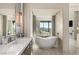 Open-concept bathroom featuring dual sinks, a soaking tub, and serene views, creating a tranquil retreat at 515 Serenity Point Dr, Henderson, NV 89012