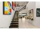 Bright, open foyer featuring a modern staircase, sleek tile flooring, and stylish wall art at 515 Serenity Point Dr, Henderson, NV 89012