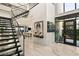 Bright foyer features a floating staircase, large windows, and elegant decor with a bar area in the background at 515 Serenity Point Dr, Henderson, NV 89012