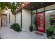 Modern home exterior featuring a red front door, artistic potted plants, and a neutral color palette at 515 Serenity Point Dr, Henderson, NV 89012