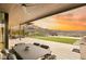 Covered patio with outdoor seating, a manicured lawn, and panoramic views of a stunning sunset at 515 Serenity Point Dr, Henderson, NV 89012
