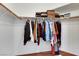 Walk-in closet with clothes hanging on the rack and items on the top shelf at 520 Blackbird Knoll Ct, North Las Vegas, NV 89084