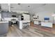 Open kitchen with an island, gray cabinets, pendant lights, and stainless steel appliances flowing into the living room at 520 Blackbird Knoll Ct, North Las Vegas, NV 89084
